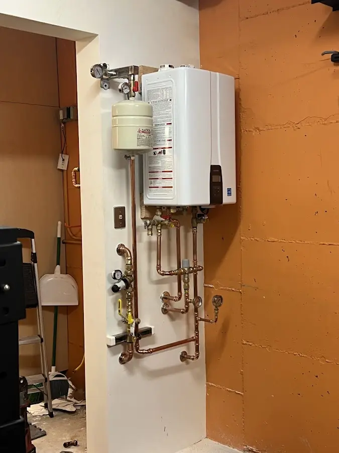 Plumbing technician inspecting water heater connections in Bar Nunn